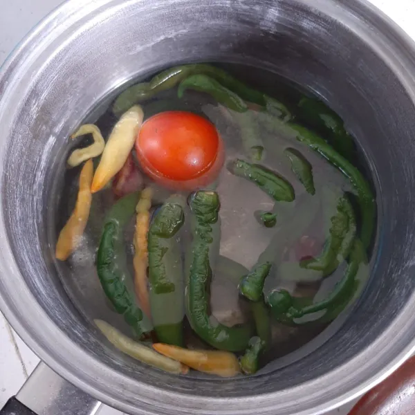 Didihkan air. Masak cabe ijo, rawit, tomat, bawang merah dan putih sampai empuk. Tiriskan