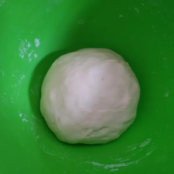 Kempiskan adonan yang sudah mengembang, bagi menjadi dua bagian.