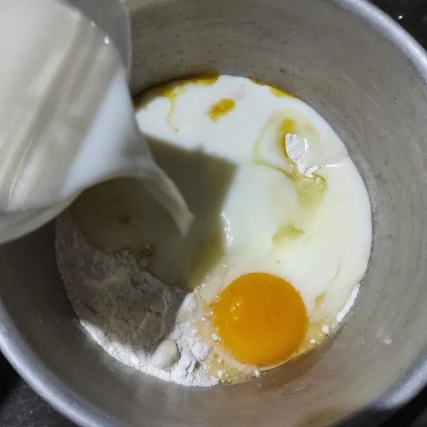 Membuat adonan kulit: masukkan tepung terigu, garam, telur dan margarin yang sudah dilelehkan dalam wadah. Tuang susu secara perlahan. Aduk rata.