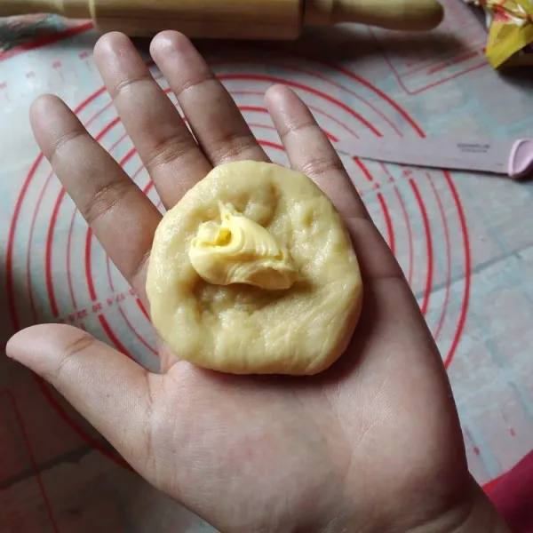 Pipihkan adonan, isi dengan mentega secukupnya, bulatkan kembali, lakukan hingga semua adonan habis