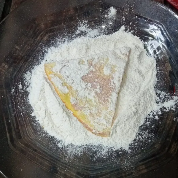 Lalu baluri telur dadar dengan tepung bumbu hingga merata.