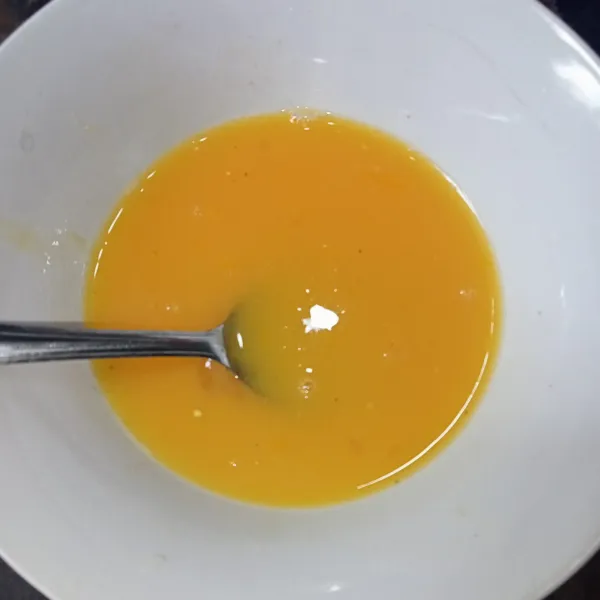 Pecahkan telur dam tambahkan garam, kaldu jamur dan lada bubuk, lalu kocok lepas.