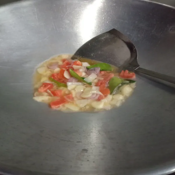 Panaskan minyak goreng, tumis bawang merah, bawang putih, bawang bombai, tomat dan daun jeruk hingga tomat hancur.