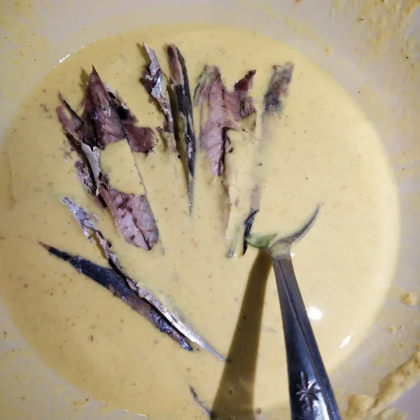 Kemudian masukkan ikan pindang ke dalam tepung yang sudah dibumbui, aduk sampai rata.