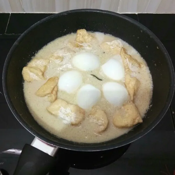 Lalu masukkan telur rebus dan tahu goreng. Aduk perlahan.