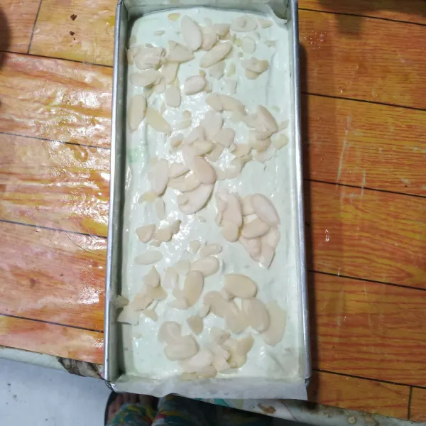 Tuang ke dalam loyang yang sudah diolesi margarin dan dialasi baking paper. Hentakan pelan lalu taburi almond slices.