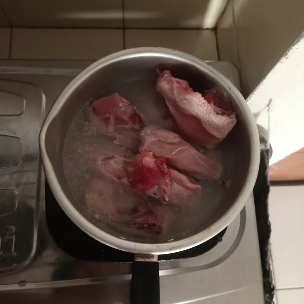 Rebus ayam dalam panci yang berisi air.