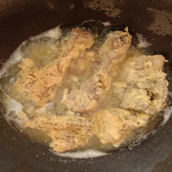 Panaskan minyak, lalu goreng ayam dengan api sedang cenderung kecil, hingga kuning keemasan.