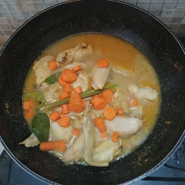 Masukkan ayam, aduk sebentar lalu tuang air, masak sampai mendidih lalu masukkan irisan wortel.