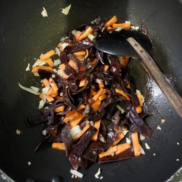 Tambahkan irisan wortel, aduk rata dan biarkan beberapa saat. Selanjutnya masukkan jamur kuping.