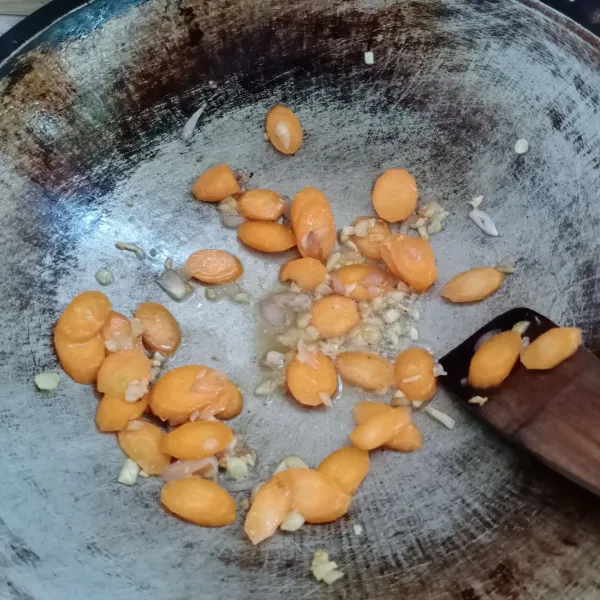 Masukkan wortel, tumis sebentar. Kemudian masukkan air. Masak sampai wortel setengah matang.