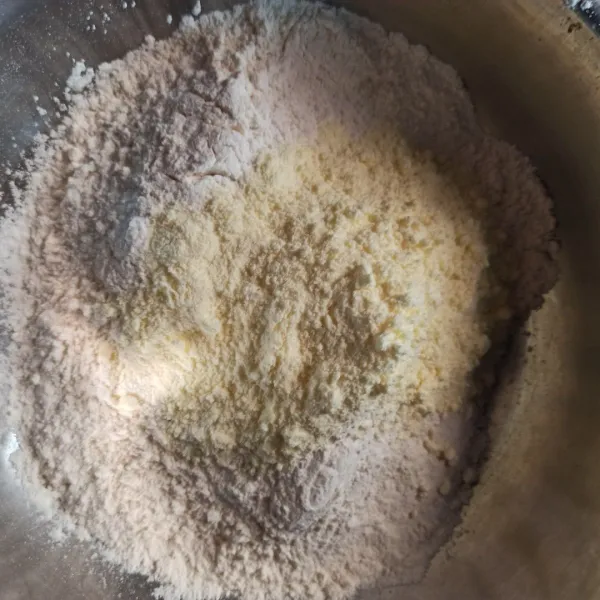 Campur tepung terigu dan susu bubuk, lalu buat lubang di tengahnya