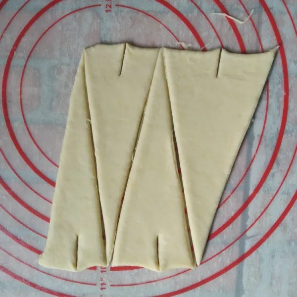 Gilas adonan setebal 0,5 cm potong bentuk segitiga, potong juga bagian tengahnya sedikit