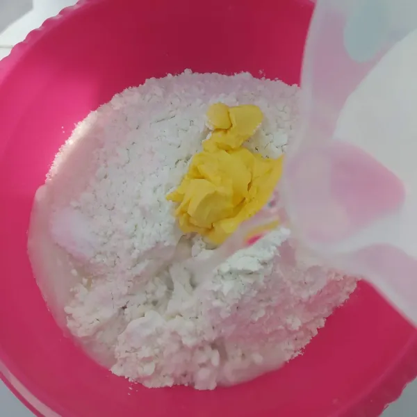 Masukkan tepung terigu, gula pasir, garam dan margarin. Tuang air sedikit demi sedikit sambil diuleni hingga kalis.