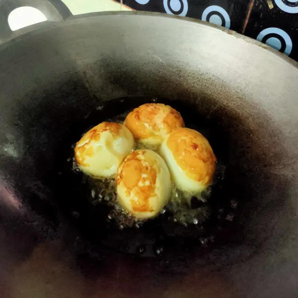 Rebus telur, kupas, kemudian goreng angkat dan tiriskan.