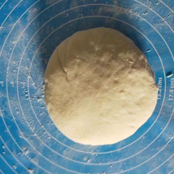 Setelah 90 menit kempiskan adonan, transfer ke meja kerja yang sudah ditaburi tepung. Adonan lengket ya.