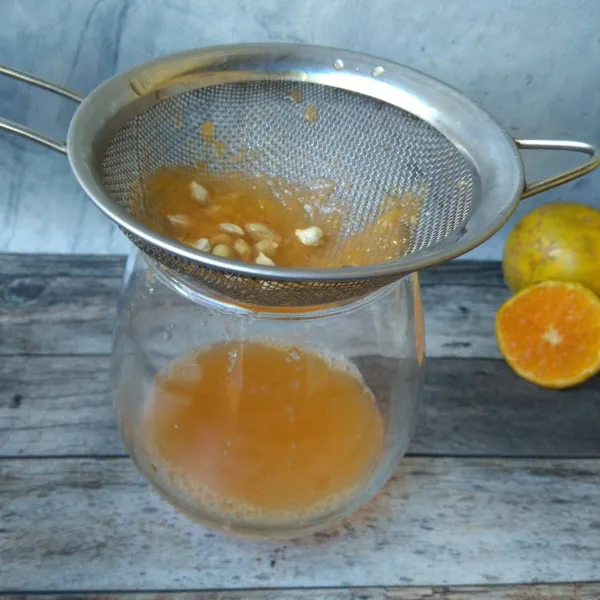 Peras dan saring sari buah jeruk lalu masukkan ke dalam gelas.