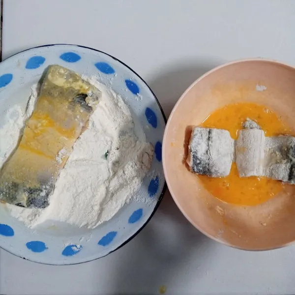 Gulingkan ikan ke dalam tepung kering. Celupkan ke dalam kocokan telur dan gulingkan kembali ke dalam tepung kering.