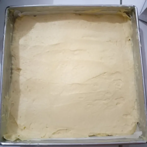 Siapkan loyang ukuran 20cm. Olesi dengan mentega, lalu alasnya alasi dengan kertas roti. Tuangkan adonan ke dalam loyang.