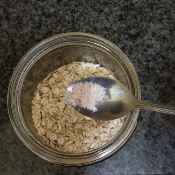 Siapkan jar, tuang rolled oats ke dalamnya, tambahkan garam himalaya.