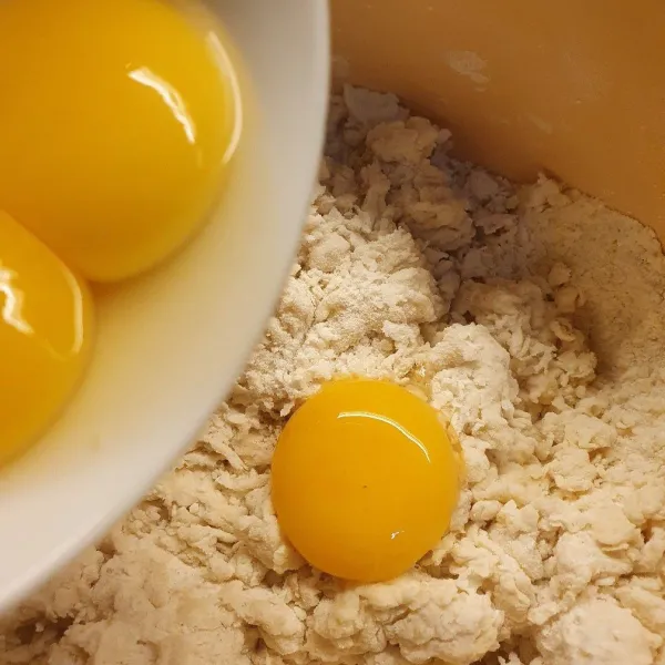 Tambahkan telur, lalu masukkan air es sedikit demi sedikit, sesuaikan saja, bisa dikurangi sedikit. Lalu masukkan bahan B sedikit demi sedikit, aduk hingga 3/4 kalis, tutup plastik dan istirahatkan -+ 15menit.