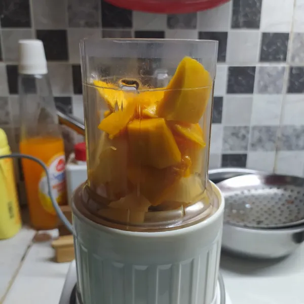 Masukkan potongan buah mangga dan blewah dalam blender.