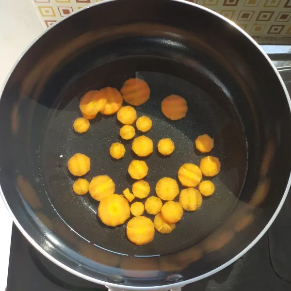 Didihkan air di panci, masukkan wortel. Masak wortel sampai setengah matang.