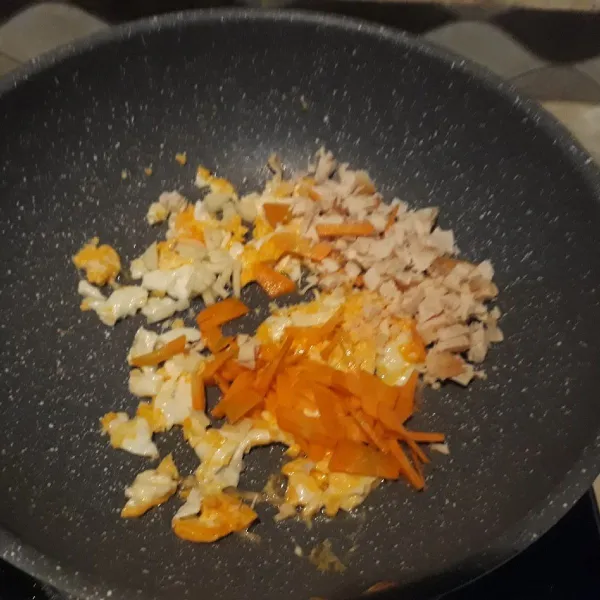 Masukkan irisan wortel, ayam suwir dan bawang putih cincang halus.