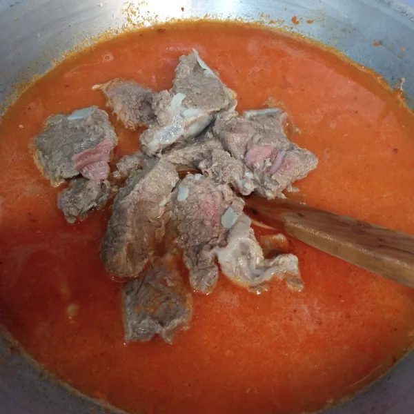 Masukkan daging sapi, garam, gula pasir dan kaldu bubuk, masak dengan api besar hingga airnya mulai menyusut dan bumbu meresap.
