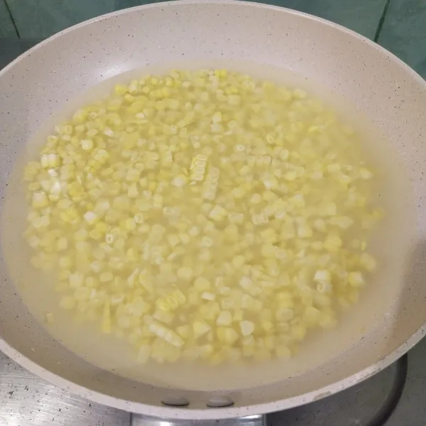 Langkah yang pertama cuci bersih jagung manis kemudian kupas jagung lalu rebus hingga matang.