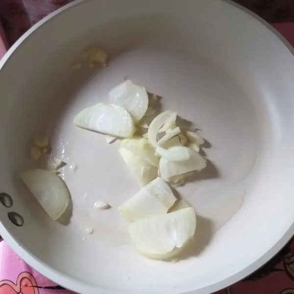 Iris bawang bombai dan cincang bawang putih, panaskan minyak kemudian tumis hingga harum.