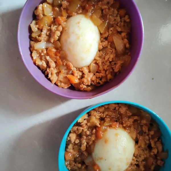 Belah 2 telur, simpan di mangkuk, tambahkan ayam bumbu.
