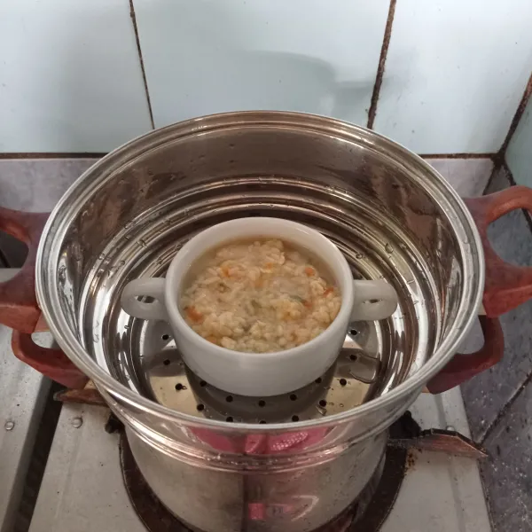 Siapkan wadah tahan panas. Tuang bubur nasinya, beri air panas secukupnya. Kukus selama 20 menit.