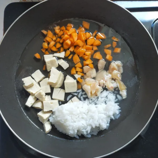 Masukkan wortel, daging ayam, tahu dan nasi.