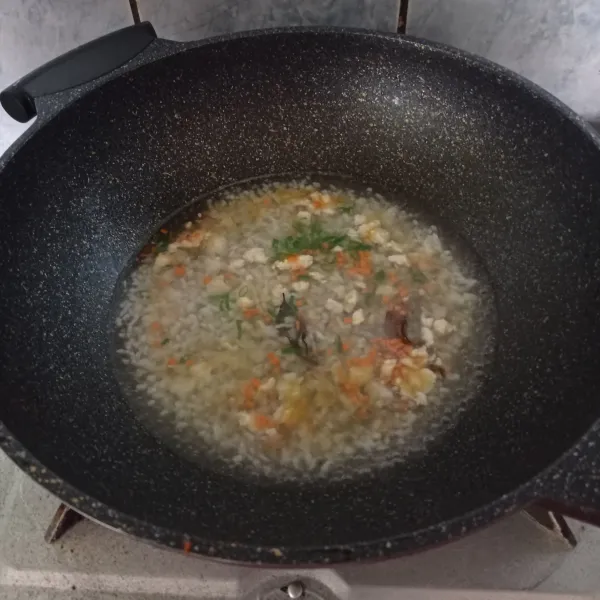 Tuangi air, masukkan nasi, wortel daun bawang dan daun salam.