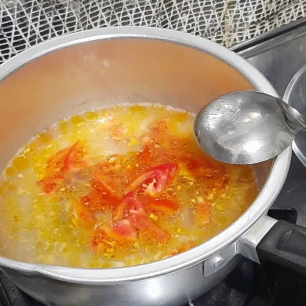 Tambahkan air lalu masukkan tomat yang sudah dipotong-potong.