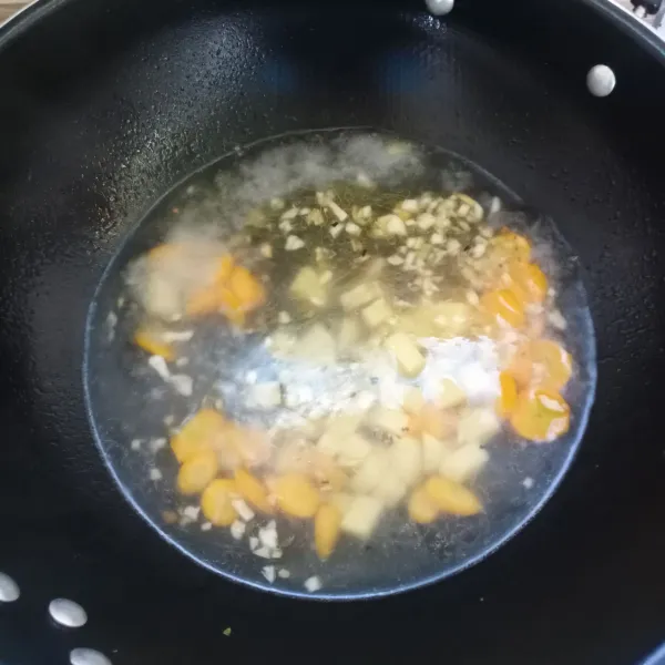 Masukkan air, masak sampai mendidih. Kemudian masukkan kentang dan wortel. Masak sampai empuk.