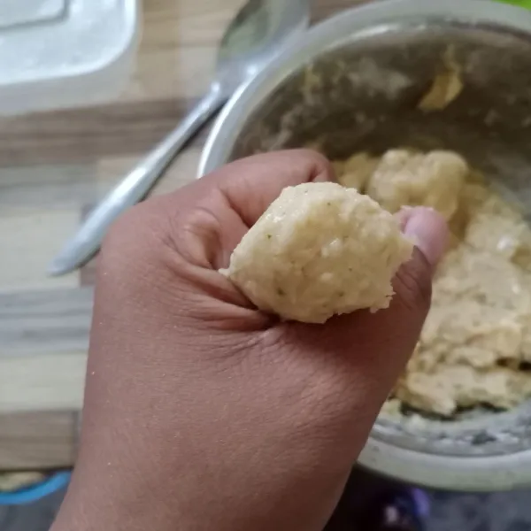 Panaskan minyak goreng. Bentuk bulat adonan dengan bantuan tangan dan sendok.