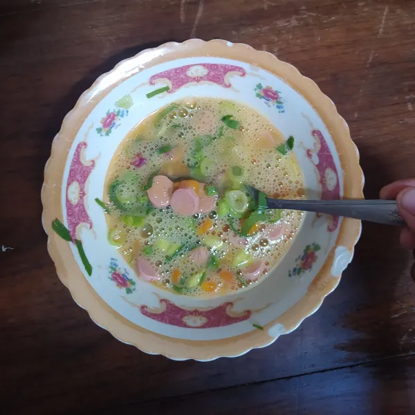 Pecahkan telur, masukkan lada, garam dan kaldu bubuk, kocok rata. Masukkan sayuran dan daun pre.