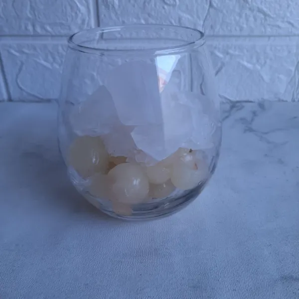 Dalam gelas saji masukkan kelengkeng, tambahkan es batu.