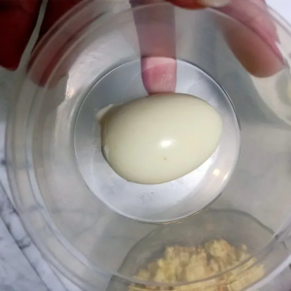 Telur matang dipotong 2 . Kemudian dibelah,  lalu siapkan ditaruh kedalam wadah.