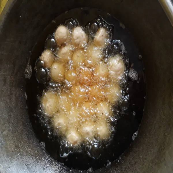 Masukkan adonan dalam minyak di atas wajan sampai adonan terendam minyak. Kemudian nyalakan kompor. Goreng hingga matang.