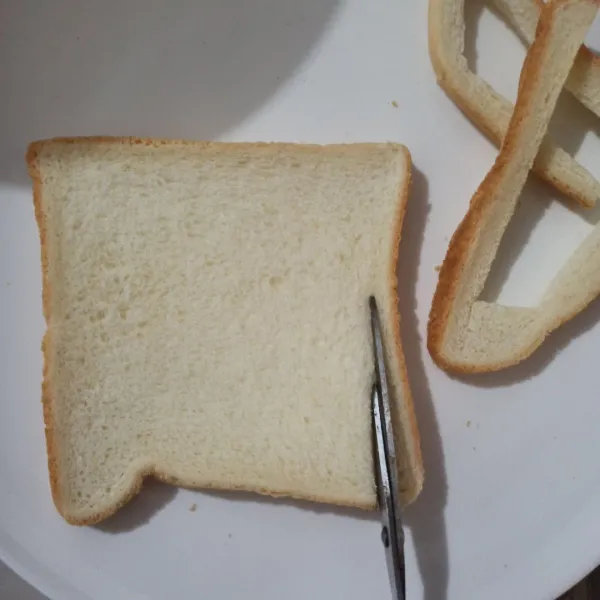 Gunting roti tawar ambil bagian pinggirnya.
