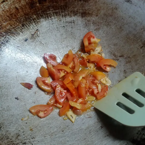 Masukkan irisan tomat, tumis sampai tomat layu.