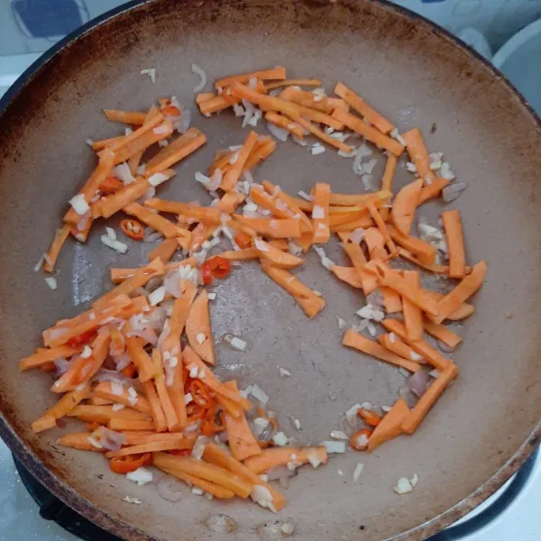 Tambahkan air, lalu masukkan cabai dan wortel.
