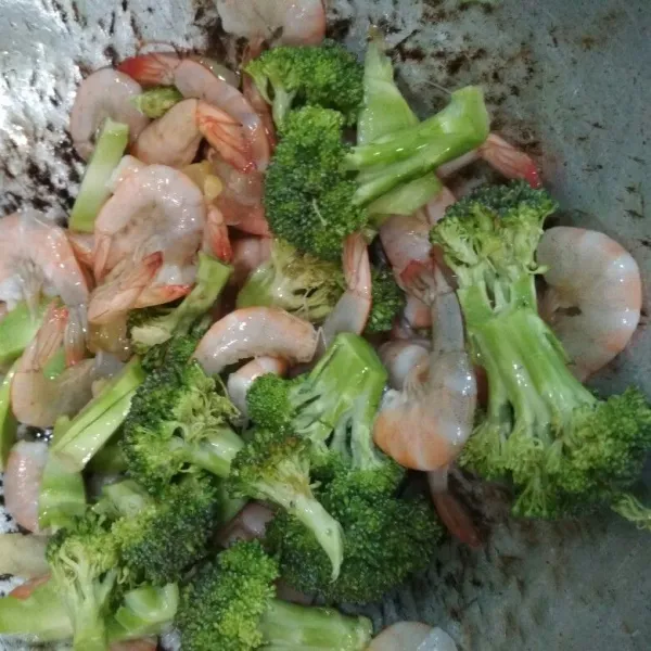 Masukkan brokoli, tambahkan air, lalu aduk rata.