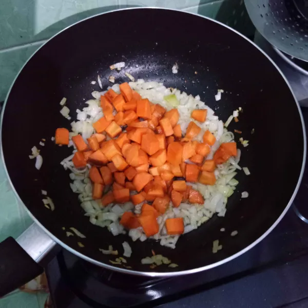Masukkan wortel, aduk rata lalu tuang air.