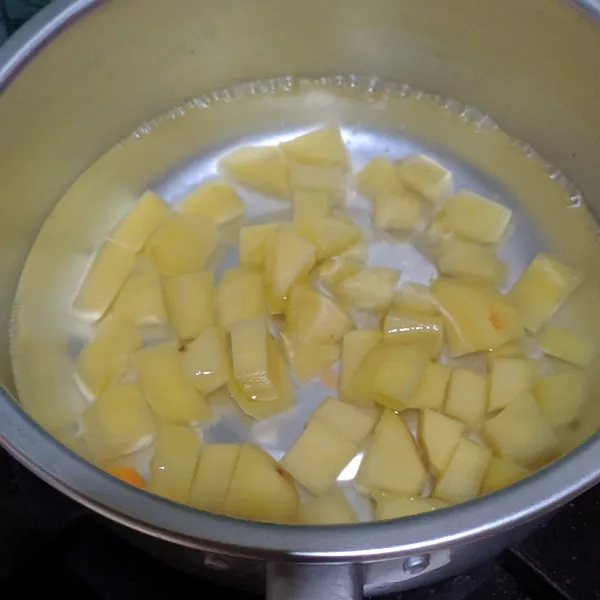 Dalam panci tuang secukupnya air, masak hingga mendidih kemudian masukan kentang. Rebus hingga setengah empuk.
