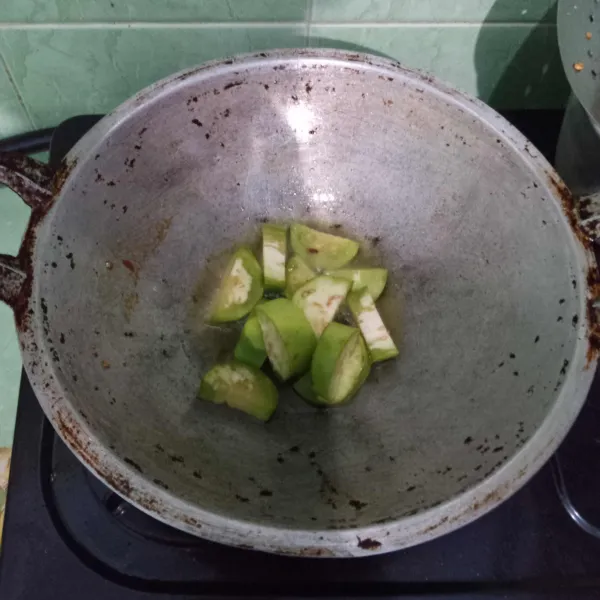 Potong terong sesuai selera, goreng terong asal empuk agar warnanya tetap hijau, lalu tiriskan.