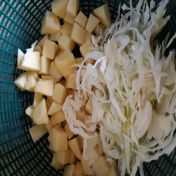 Potong dadu kentang dan iris tipis kol. Cuci bersih semuanya. Lalu rebus kentang hingga empuk.